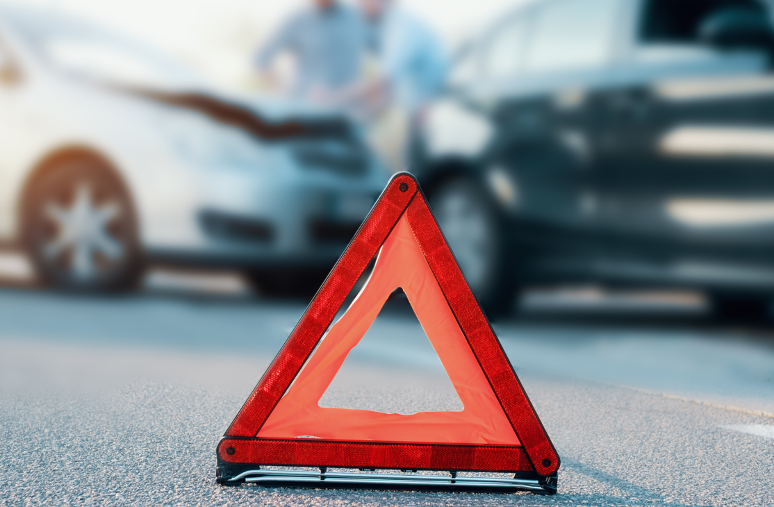 Warndreieck vor einem Unfallfahrzeug auf der Straße